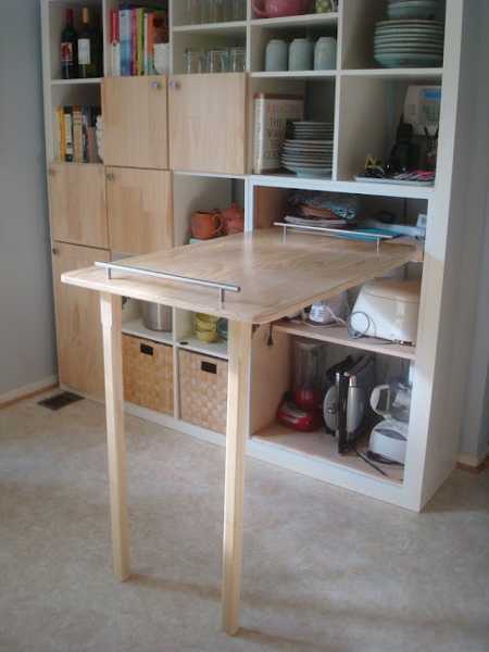 Creative idea for the kitchen with a folding wooden table as a space-saving kitchen worktop