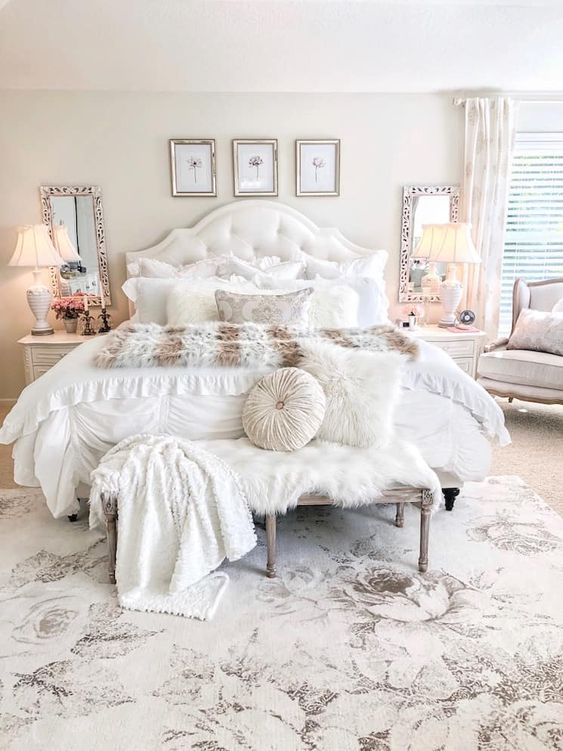 a neutral vintage bedroom with a chic gallery wall, mirrors, refined vintage furniture and faux fur and pillows