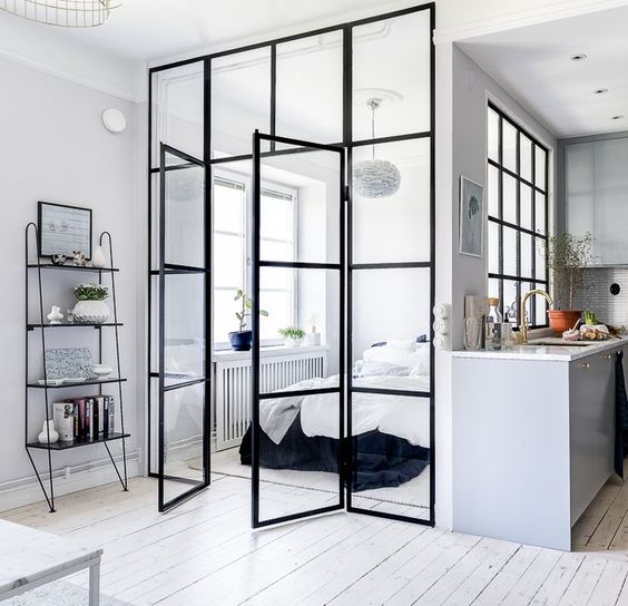 a monochromatic Scandinavian bedroom with a bed, a pendant lamp and stylish bedding clad in glass completely feels very airy and light-filled