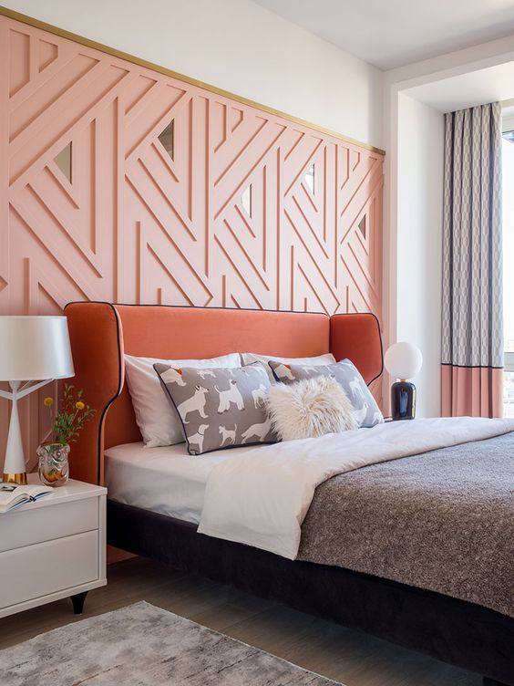 a cool modern feminine bedroom with apink geometric wall, a terracotta bed, white nightstands, color block curtains and printed bedding