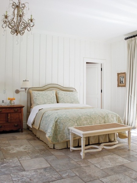 a neutral farmhouse feminine bedroom with refined furniture, with pastel textiles and a chic vintage chandelier is a beautiful space