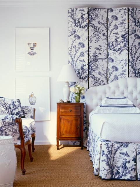 an elegant and romantic navy and white bedroom with a paneled accent wall and an upholstered bed, a chair that matches and all white or neutral is chic