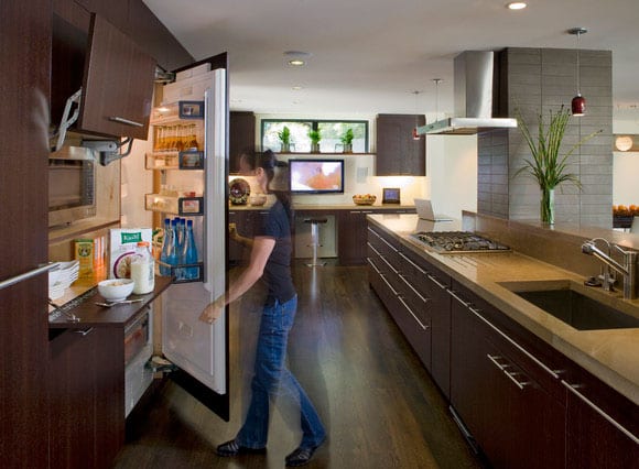 modern open kitchen in wood look with built-in electrical appliances and a large cooking island