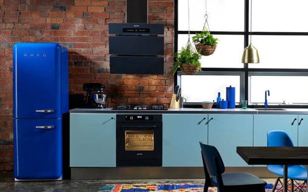 the kitchen with blue kitchen cabinets, brick wall and smeg retro refrigerator as an idea for modern kitchen equipment in blue