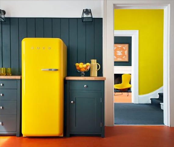 the kitchen in retro style with a living retro refrigerator smeg and gray kitchen cabinets and wooden wall paneling