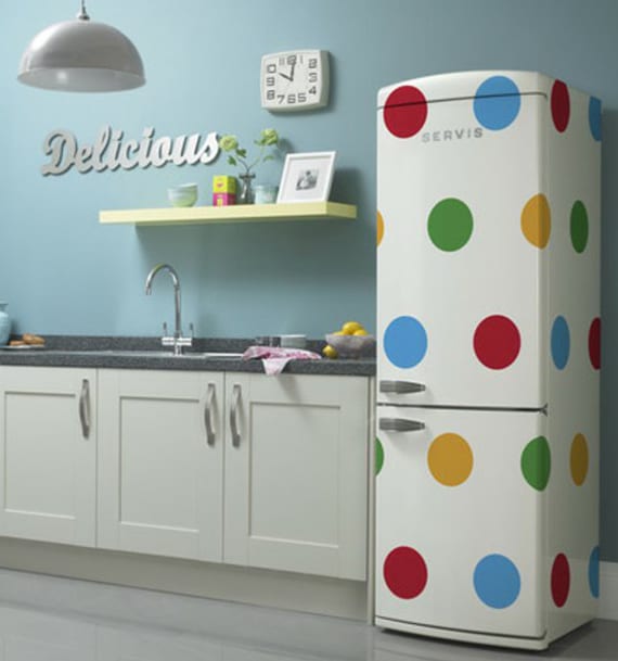 the kitchen with blue walls, white kitchen cabinets and white retro refrigerator with colored dots