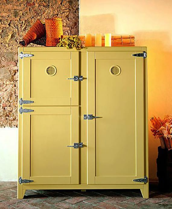 retro refrigerator with wooden cabinet doors in yellow for kitchen in retro style with stone wall