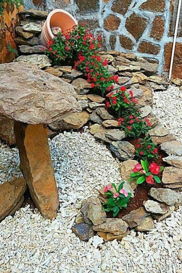 Red flowers spilling out of rock waterfall